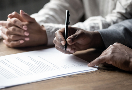 Two people signing documents.