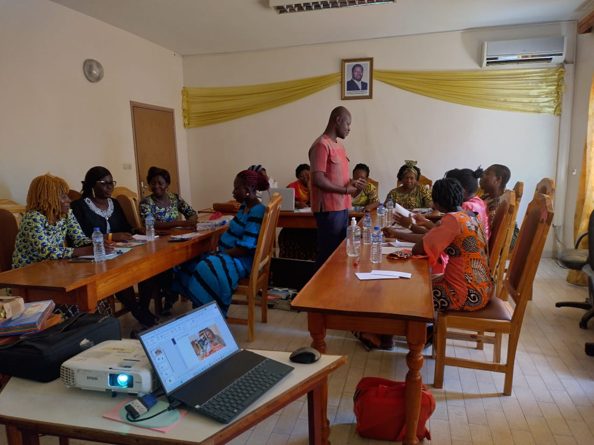 A group of women sitting in a classroom setting interacting with the teacher.