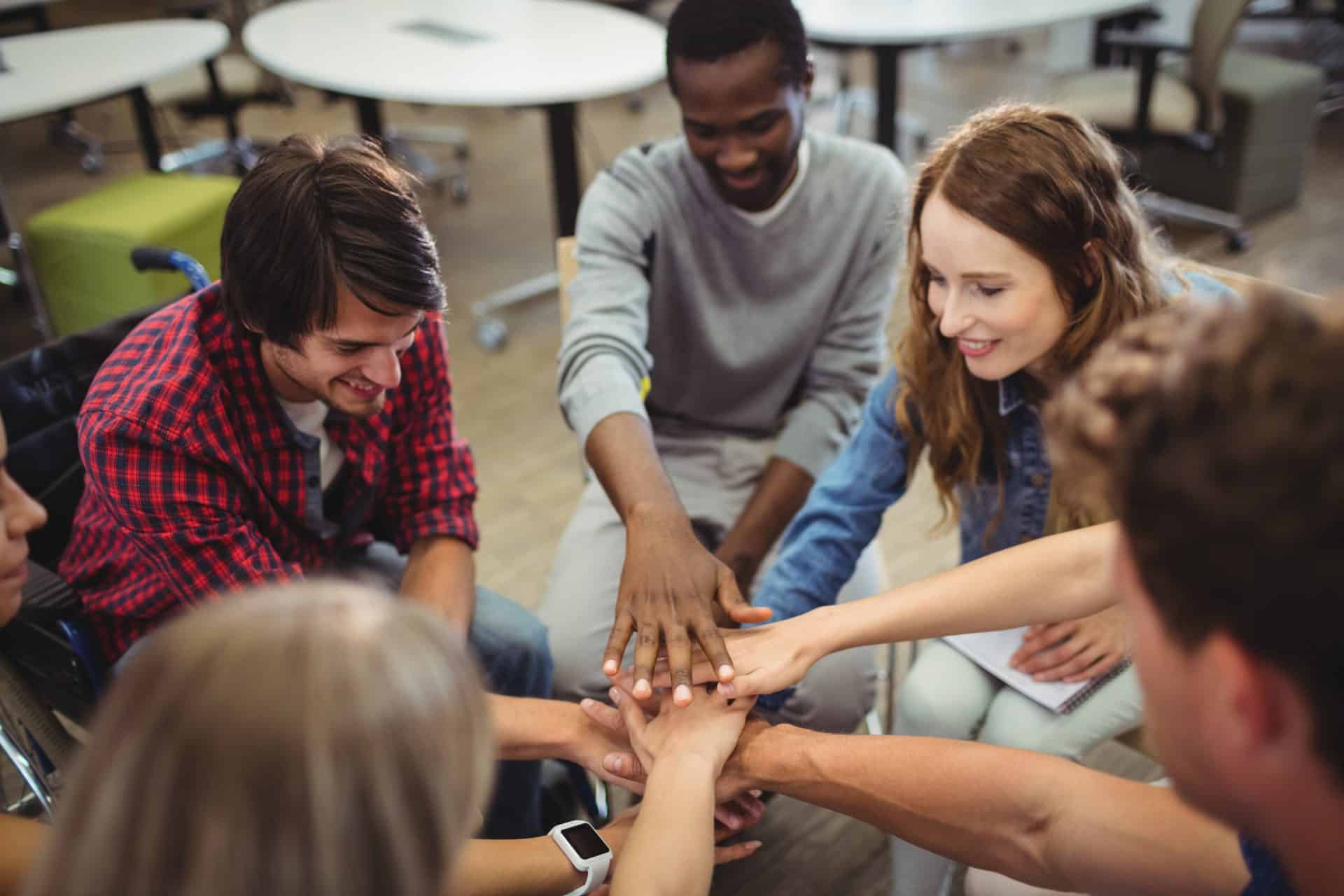 Group of differently abled people stacking their hands.