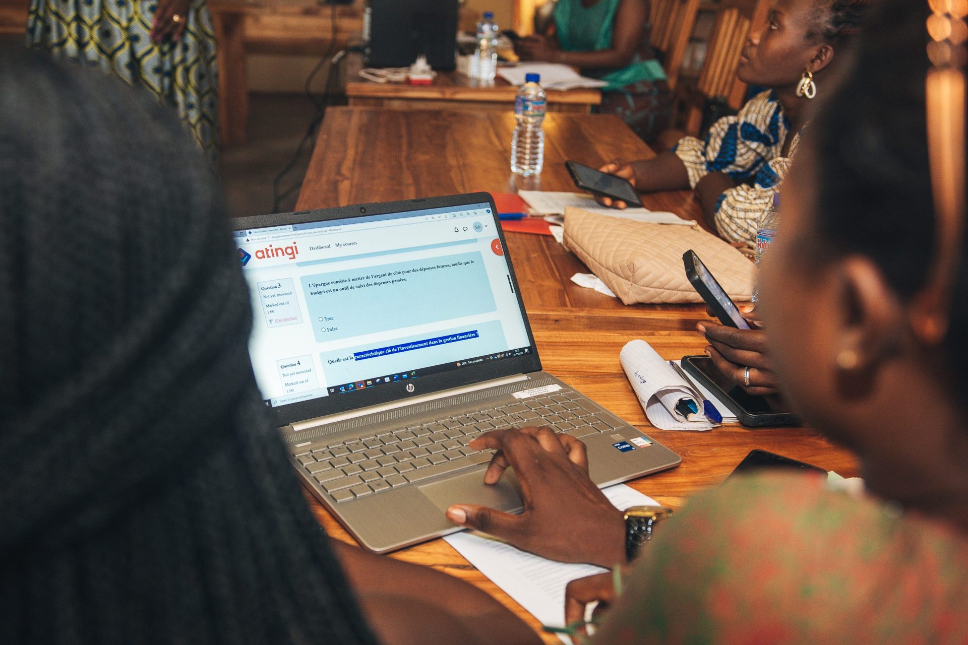 View of a laptop showing atingi course with woman working on it