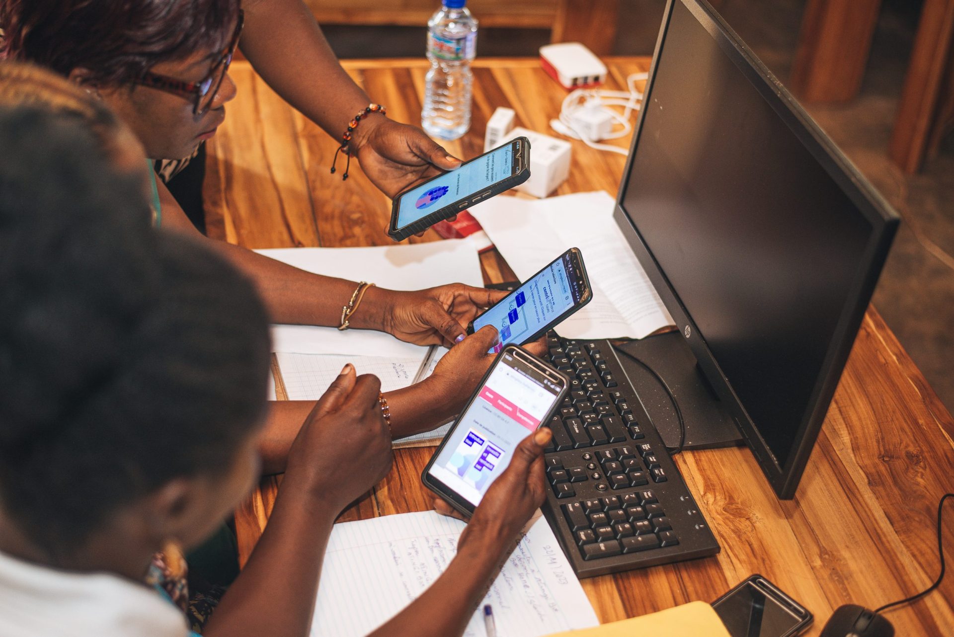 Women registering on atingi on their smartphones