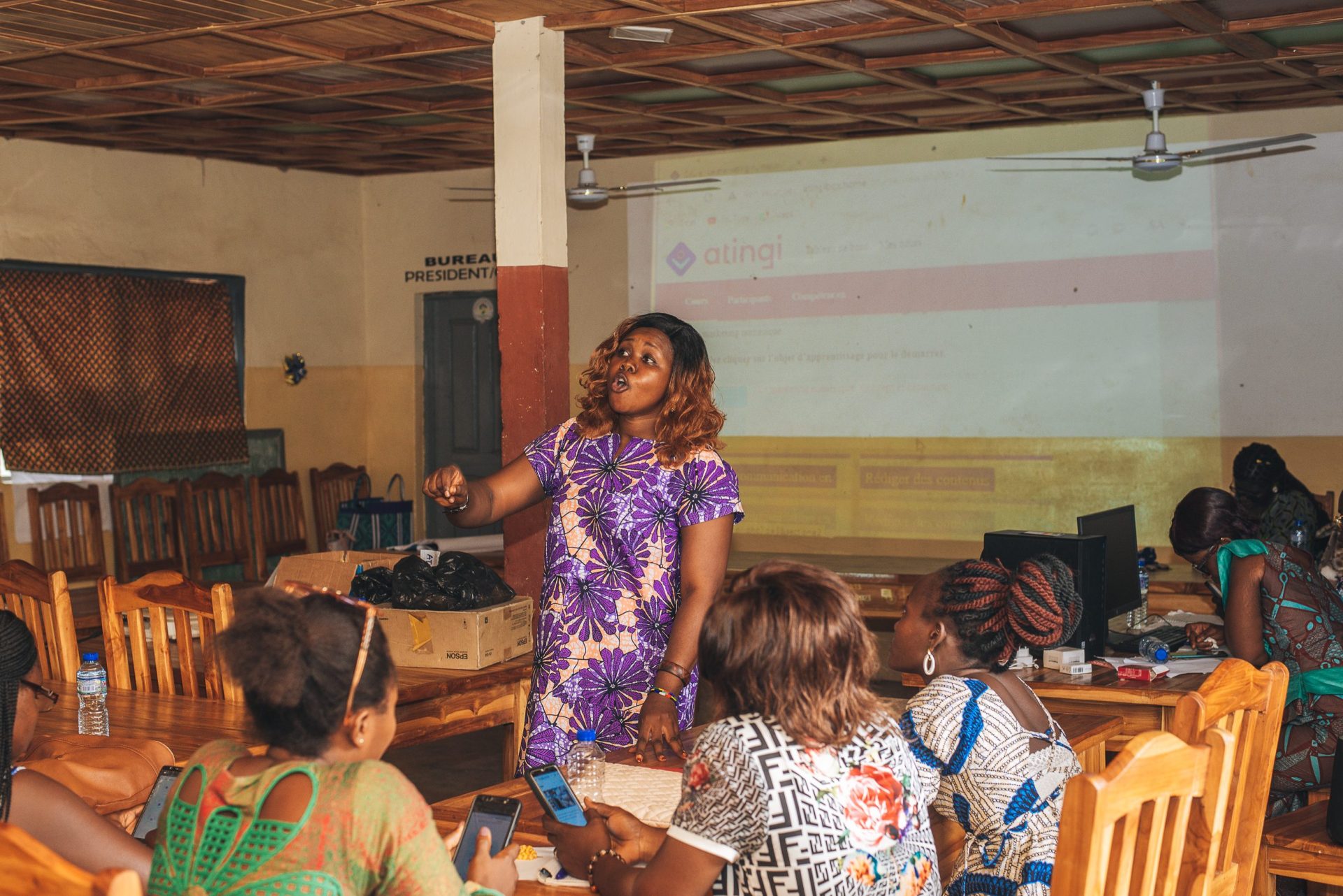 Woman speaking to a group of other women about atingi