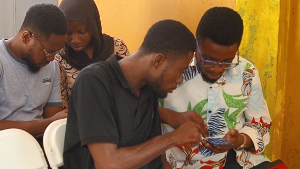 Four students looking into their smart phones