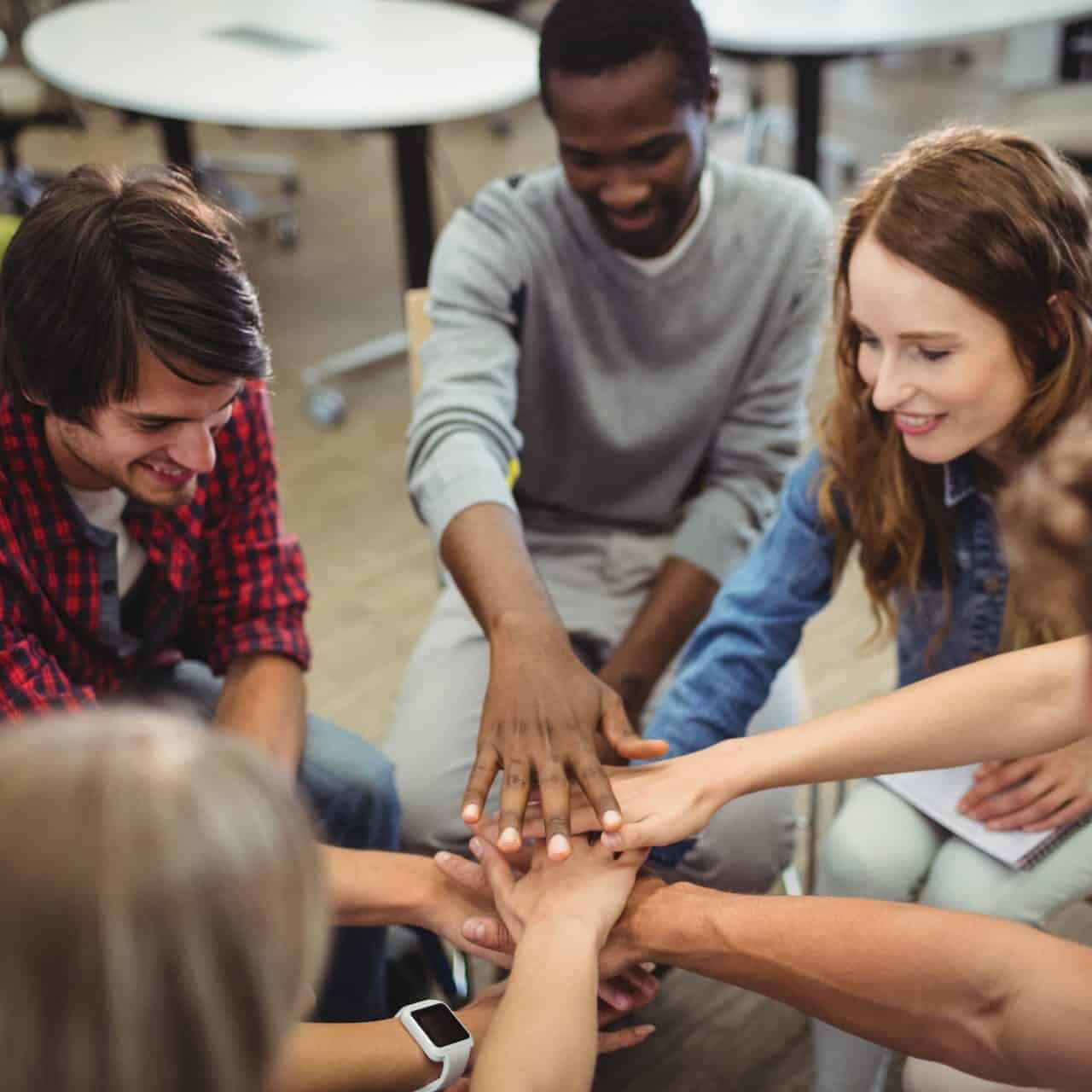 Group of differently abled people stacking their hands.